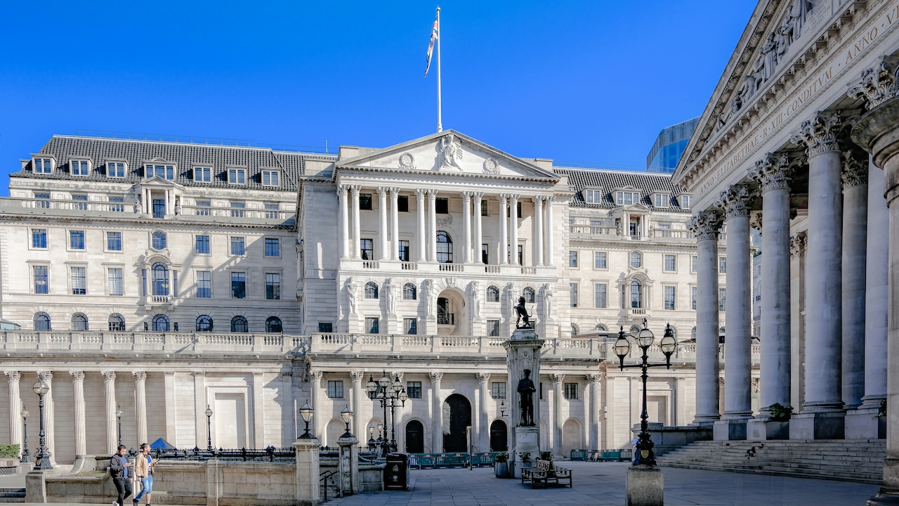 A wide angle photo of the Bank of England with a blue sky